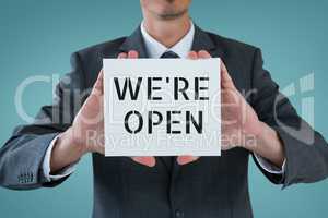 Business man holding a card with we are open text