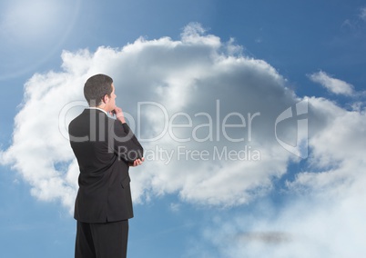 Businessman under sky clouds