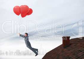 Businessman floating with balloons by Roof with chimney and foggy city