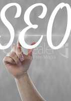 Hand interacting with SEO business text against grey background