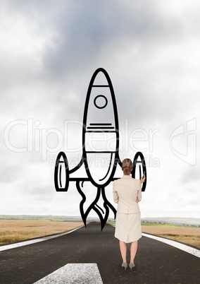 Business woman drawing a rocket on the road