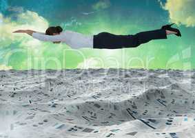 Businesswoman flying over sea of documents under green sky clouds