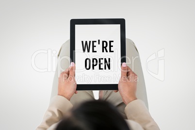 Business woman holding a tablet with we are open text