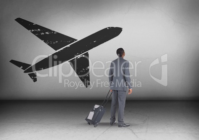 Businessman with travel bag looking up with plane icon