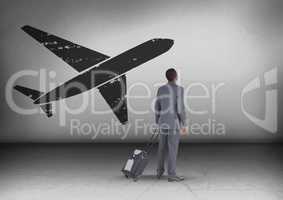 Businessman with travel bag looking up with plane icon