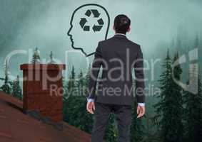 Head with recyclable sustainable icon and Businessman standing on Roof with chimney and misty forest