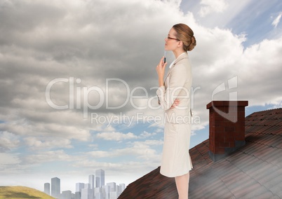 Businesswoman standing on Roof with chimney and city in distance