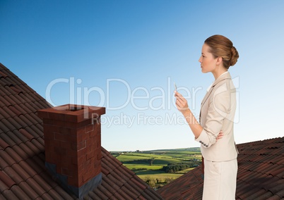 Businesswoman standing on Roofs with chimney and green country landscape