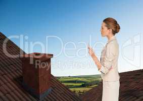 Businesswoman standing on Roofs with chimney and green country landscape