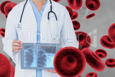 Doctor woman holding a radiograph with 3D cells against grey background