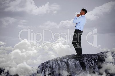 Composite image of thoughtful businessman standing against white background