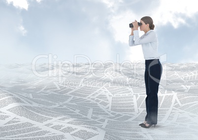 Businesswoman holding binoculars in sea of documents under sky clouds