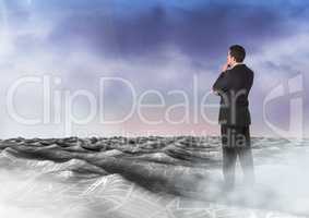 Businessman in sea of documents under sky clouds