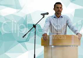 Businessman on podium speaking at conference with abstract polygon background