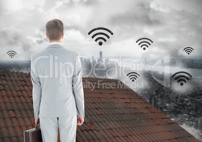 Wi-fi icons and Businessman standing on Roof with chimney and misty city