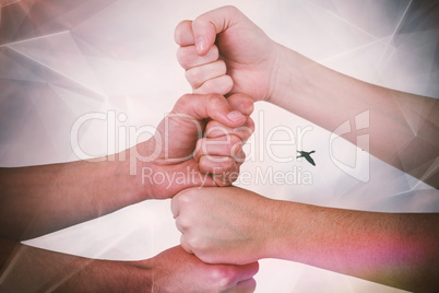 Composite image of cropped image of people with stacked fists