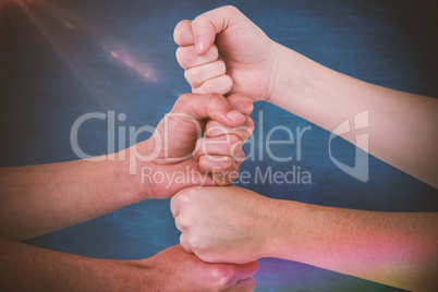 Composite image of cropped image of people with stacked fists