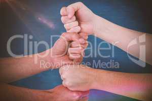 Composite image of cropped image of people with stacked fists