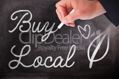 Composite image of hand holding a chalk and writing something