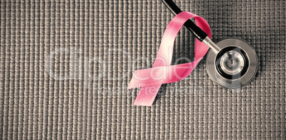 Directly above view of stethoscope by pink Breast Cancer Awareness ribbon