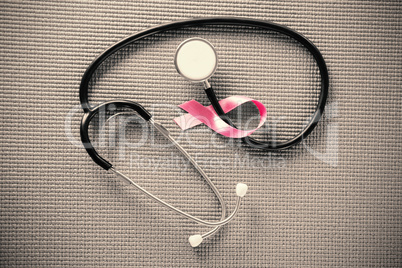 Overhead view of stethoscope by pink Breast Cancer Awareness ribbon