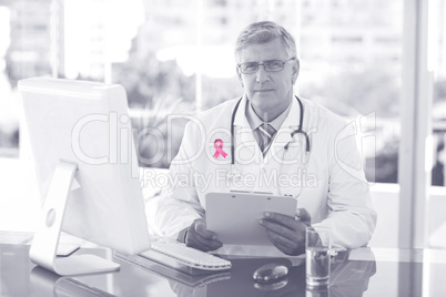 Composite image of portrait of confident male doctor sitting at computer desk