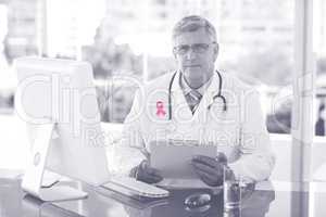 Composite image of portrait of confident male doctor sitting at computer desk