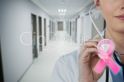 Composite image of close-up of female doctor holding stethoscope