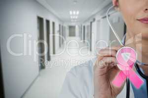 Composite image of close-up of female doctor holding stethoscope