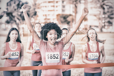 Cheering young woman winning breast cancer marathon