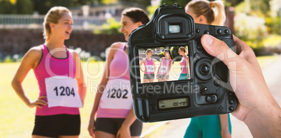 Composite image of cropped hand of photographer holding camera