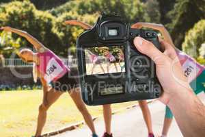 Composite image of cropped hand of photographer holding camera