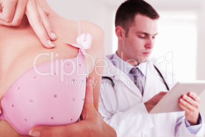 Composite image of mid section of woman wearing pink bra for breast cancer awareness