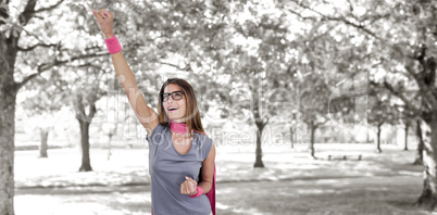 Composite image of smiling woman in superhero costume with arm raised