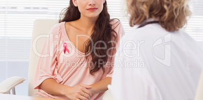 Composite image of female patient listening to doctor with concentration in medical office