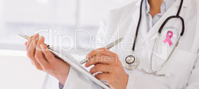 Composite image of mid section of a female doctor writing reports