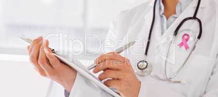 Composite image of mid section of a female doctor writing reports