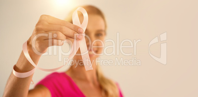 Close-up of young woman holding pink ribbon