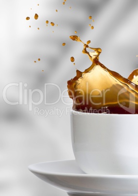 White cup with coffee splashing against blurry grey stairs