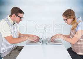 Nerd couple at laptops against blurry blue wood panel