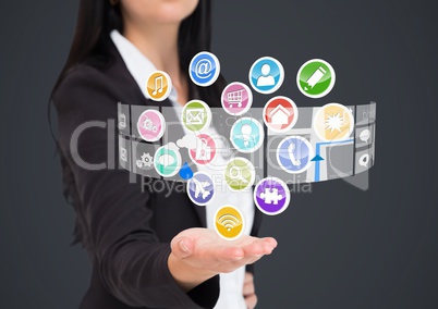 Businesswoman with hand spread of  and application icons coming up from it. Grey background