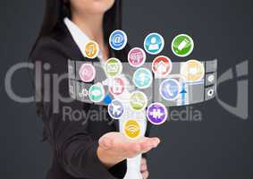Businesswoman with hand spread of  and application icons coming up from it. Grey background