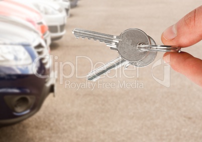 Hand  Holding key in front of cars