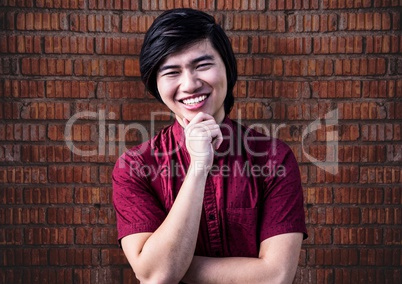 Millennial man hand on chin against brick wall