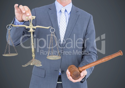 Male judge mid section with gavel and scales against grey background