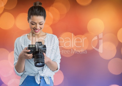 photographer looking the photos on camera. Blue and orange bokeh background