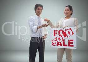 Man and woman with for sale sign and keys in front of vignette