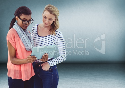 Millennial women with tablet against blue room