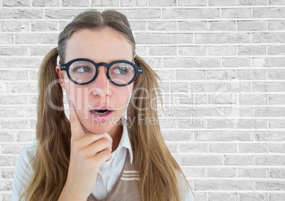 Close up of nerd woman thinking against white brick wall