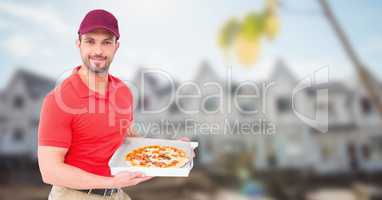 Delivery man with pizza against blurry housing estate